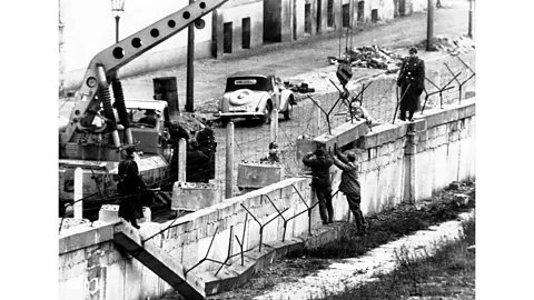 Getty Images East Germany builds the Berlin Wall in 1961 to stop East Germans from leaving for the West (Credit: Getty Images)