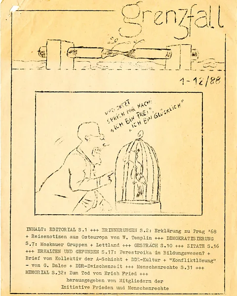 Robert-Havemann-Gesellschaft A cover of East Germany's 1988 clandestine Grenzfall magazine, with a man telling a parrot: "And now repeat after me: I am free. I am happy" (Credit: Robert-Havemann-Gesellschaft)