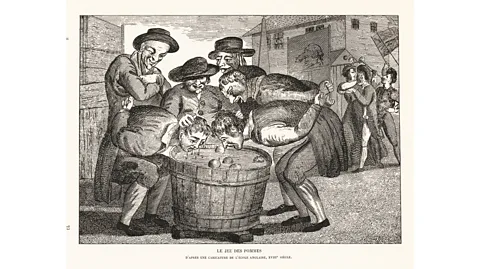 Getty Images It is thought that apple bobbing originated in the 14th Century – or possibly even further back (Credit: Getty Images)