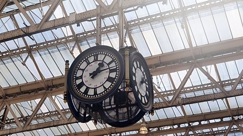 Clock hanging from the roof of a railway station