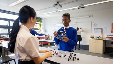 Two students building molecular models in a classroom