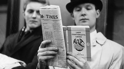 Getty Images Two men holding a newspaper and a copy of Lady Chatterley's Lover (Credit: Getty Images)