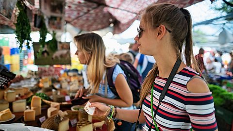 Mother and daughter buying cheese at a market