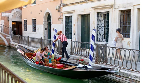 Carola Cappellari Sandolista and tourists on a sandolo in a Venetian canal (Credit: Carola Cappellari)