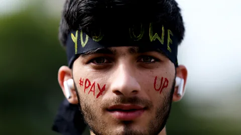 Getty Images A Nepali activist poses for a photo with slogans calling for climate justice on his face in Lalitpur, Nepal (Credit: Getty Images)