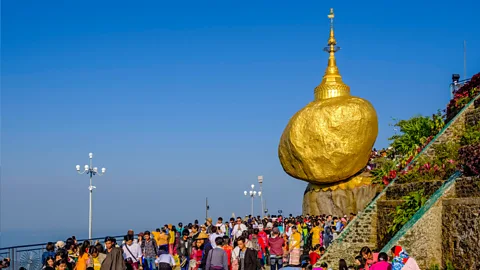 Getty Images The Golden Rock in Myanmar is a precarious boulder that has acquired religious significance and is now a major tourist attraction (Credit: Getty Images)