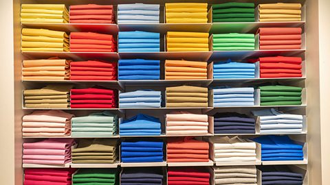 Shelves filled with a variety of different coloured polo shirts