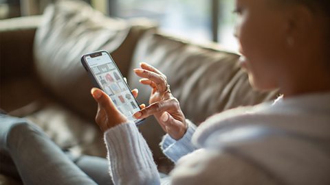 Female teenager looking at a clothing app on her phone