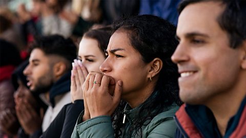 Tense looking people at a football match