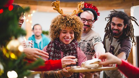 People takin cake from a serving board at a Christmas party