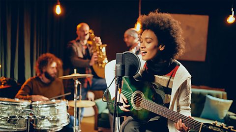 Female singer playing the guitar at a gig