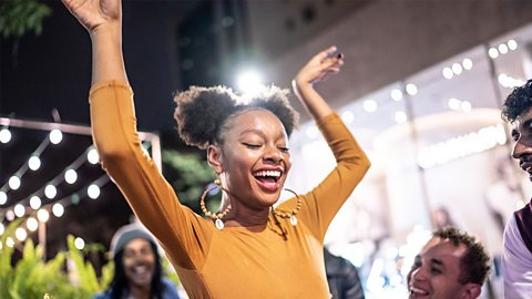 Smiling female teeanger dancing outside at night