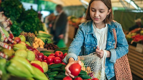 Female teenager choosing vegetables at a market