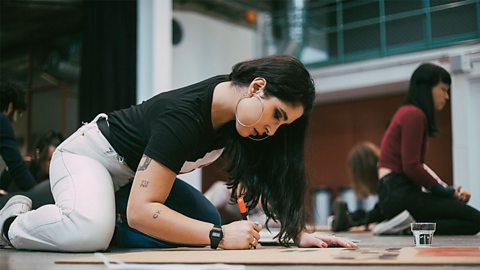Young woman designing a poster for a demonstration