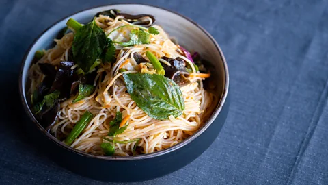 Lauren Cutshall Vang mixes rice noodles with shredded cabbage and vegetables (Credit: Lauren Cutshall)