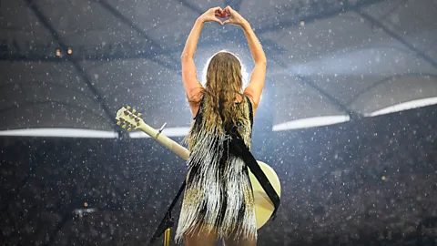 Getty Images Taylor Swift on the Eras tour with her back to the camera making heart shape (Credit: Getty Images)