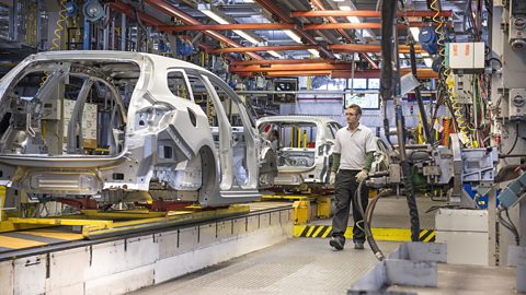 Worker operating machinery at a car factory
