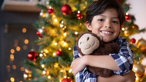 Boy looking very happy after getting a toy monkey for Christmas.