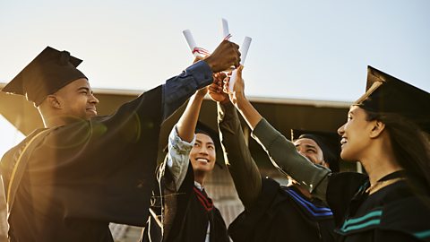 Four people celebrating getting their masters degree to help them get recruited.