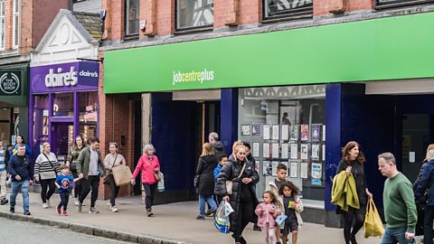 A job centre in a high street with people walking past it.