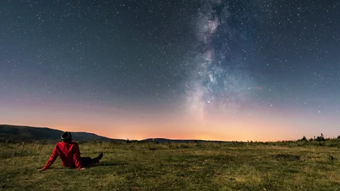 Getty Images Man lying on the grass watching the Milky Way (Credit: Getty Images)