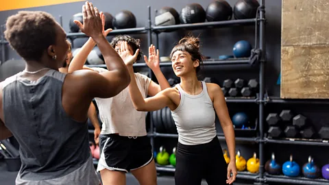 Getty Images Three women high-fiving in gym (Credit: Getty Images)