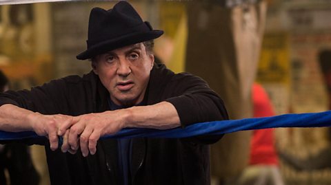 The actor Sylvester Stallone stood behind a boxing ring