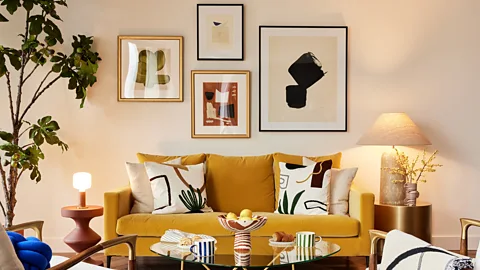 Artful Walls A living space decorated with wall art, a glass table, and a yellow sofa (Credit: Artful Walls)