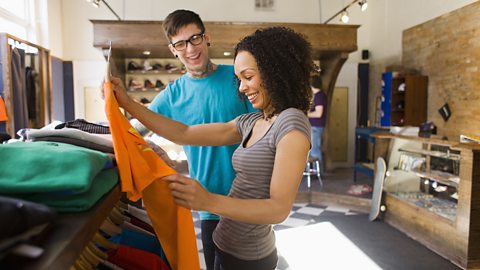 A lady buying a t-shirt at a skateboard shop