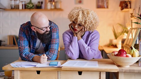 Two business partners calculating their profit and costs for their business. One is male and the other is female.