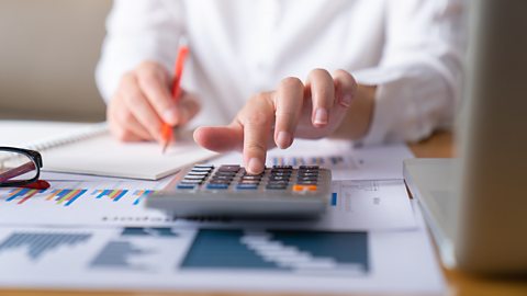 Person using a calculator to calculate what a business owes
