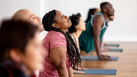 Getty Images A woman in a yoga class doing a Cobra pose (Credit: Getty Images)