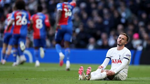 James Maddison sitting on the pitch looking dejected.