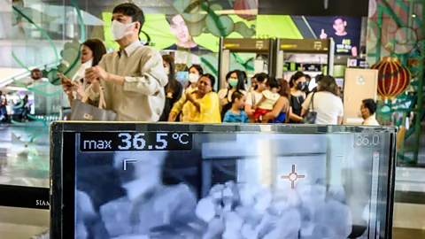 Mladen Antonov/ AFP/ Getty Images People walking past a heat scanner in a Thai shopping mall in January 2020 (Credit: Mladen Antonov/ AFP/ Getty Images)