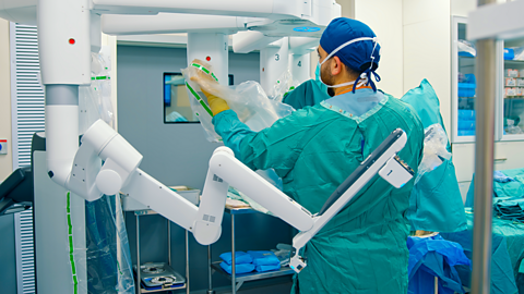 Operating room nurse preparing a surgical robot for laparoscopic surgery