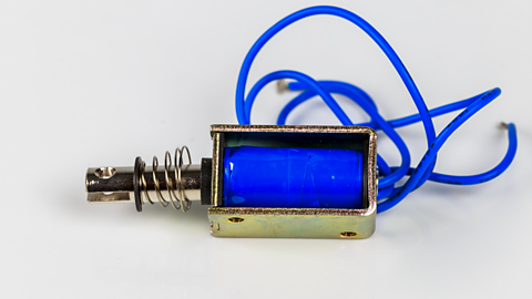 Small electric solenoid on white background