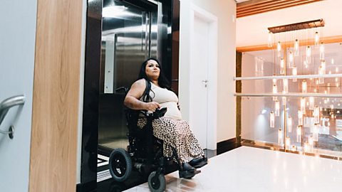 Woman in wheelchair leaving elevator
