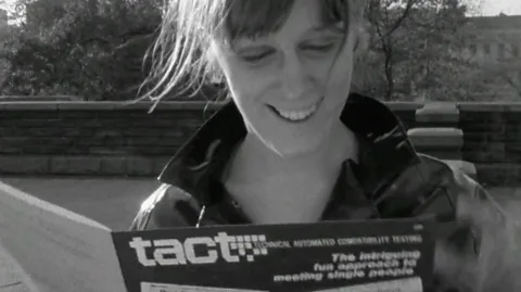 BBC women look down at the tact booklet (credit: BBC)