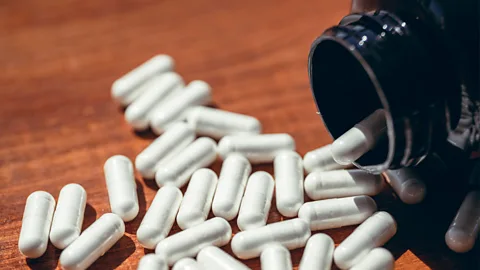 Getty Images White pill capsules spilling out of a black bottle (Credit: Getty Images)