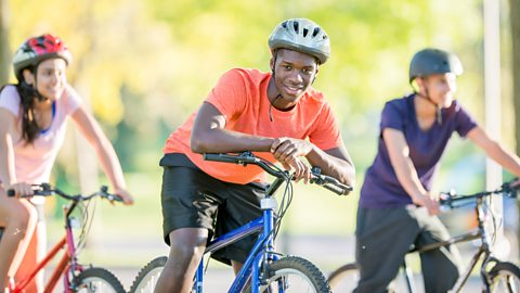 Friends riding bikes through the park