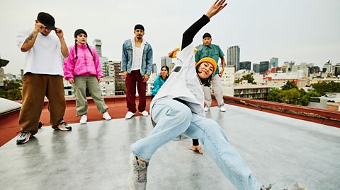 Young people dancing to hip-hop music on a roof