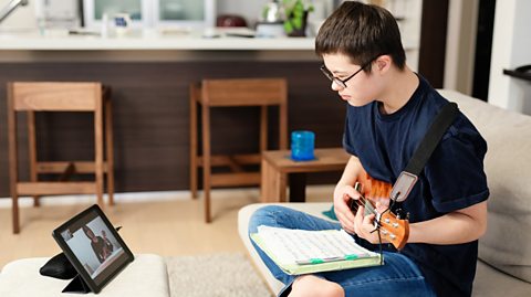 Teenage boy with Down's syndrome playing the guitar