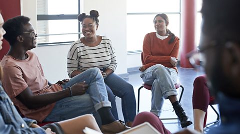 A group of students sat in a circle talking.