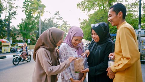 Asian Muslim group standing in the street at food market Ramadan
