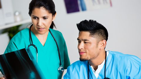 Nurse and doctor examining patient x-ray.