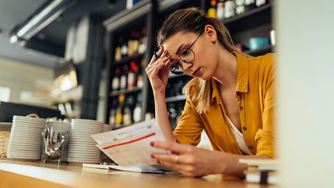 A business woman looking at her cash flow forecast to try to prevent business failure