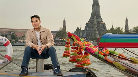 Phollachej Rattanwacherin Thai actor Dom Hetrakul sitting in front of the Wat Arun temple and a water boat (Credit: Phollachej Rattanwacherin)