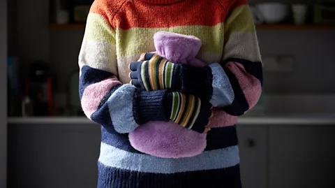 Alamy An increasing number of people are turning to hot water bottles and blankets to keep warm indoors (Credit: Alamy)