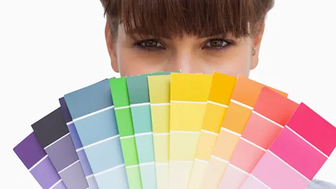 Alamy Micah Lumsden holding up colour swatches against a background of various bright colours