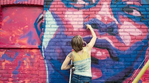 Young woman painting mural.